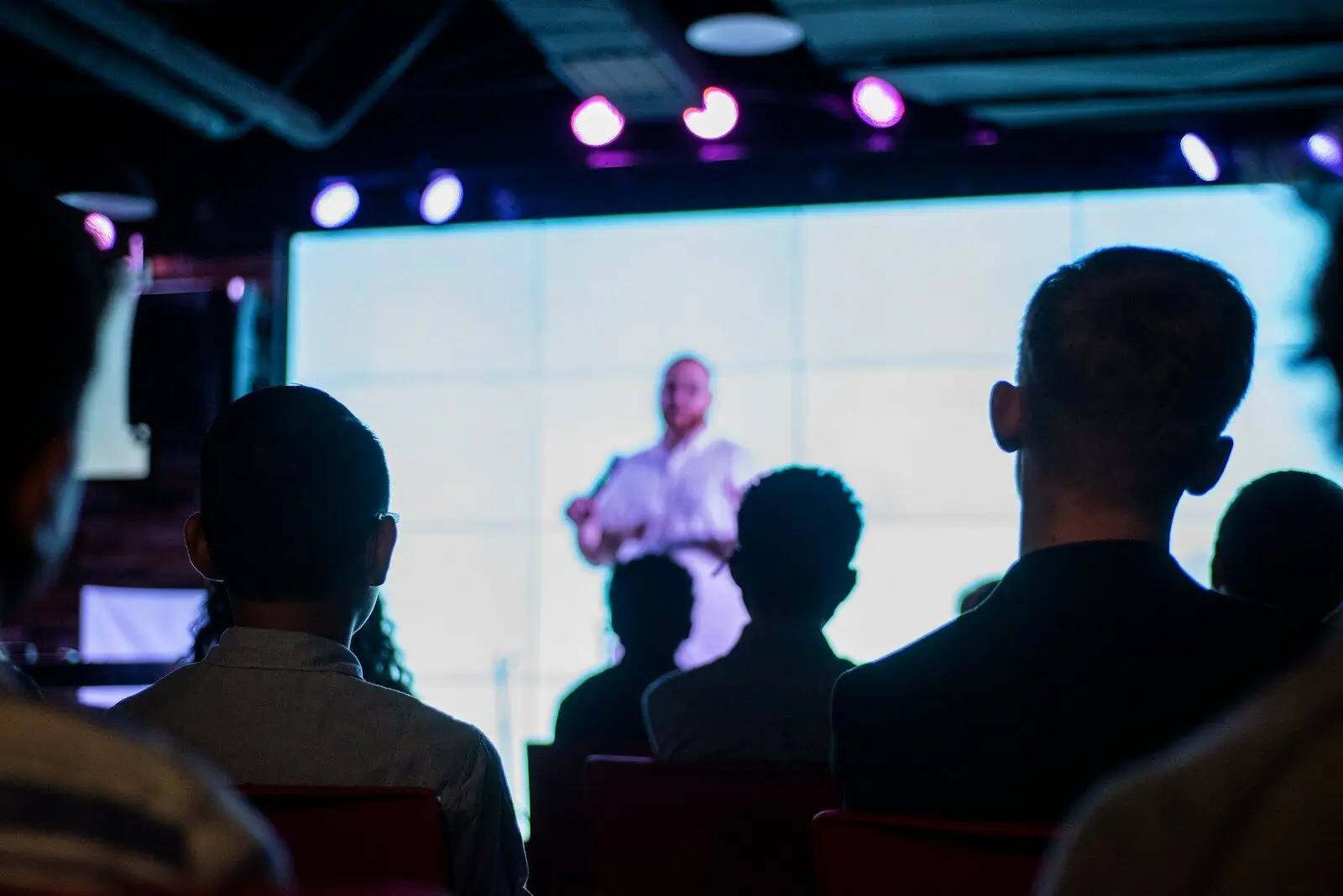 Dr. Andrew Campbell speaking on stage in front of an audience